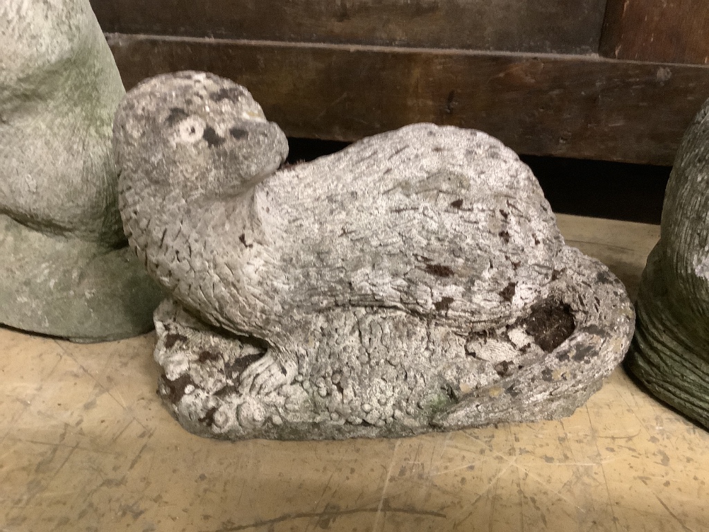 Three reconstituted stone otter garden ornaments, tallest 36cm